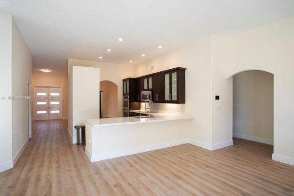 Empty room, Interior, Kitchen, Recessed Lighting, Stainless Steel Appliances, Wood Texture Flooring