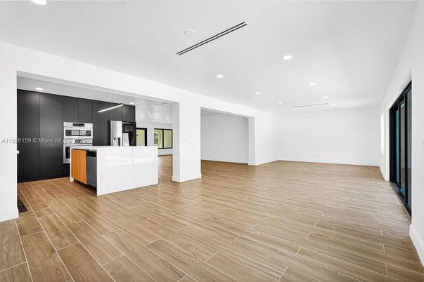 Empty room, Interior, Kitchen, Recessed Lighting, Stainless Steel Appliances, Wood Texture Flooring