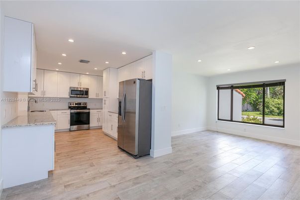 Empty room, Interior, Kitchen, Recessed Lighting, Stainless Steel Appliances, Wood Texture Flooring