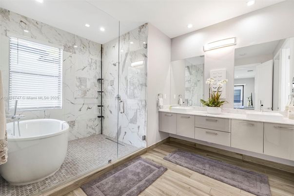 Bathroom, Dual Sink Vanities, Free Standing Baths, Glass Shower, Interior, Marble Walls, Recessed Lighting, Wood Texture Flooring
