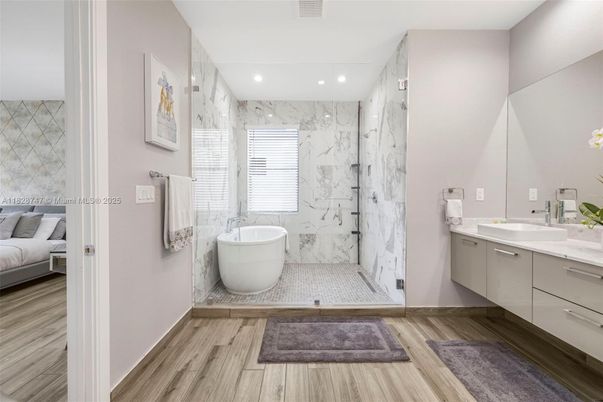 Bathroom, Dual Sink Vanities, Free Standing Baths, Glass Shower, Interior, Marble Walls, Recessed Lighting, Wood Texture Flooring