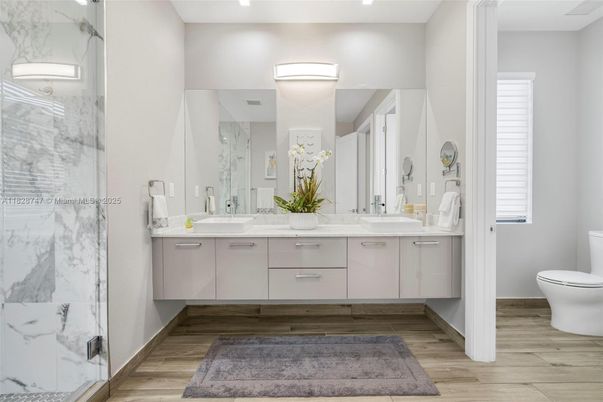 Bathroom, Dual Sink Vanities, Glass Shower, Interior, Marble Walls, Wood Texture Flooring