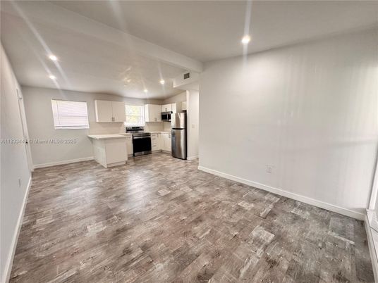 Empty room, Interior, Kitchen, Recessed Lighting, Stainless Steel Appliances, Wood Texture Flooring