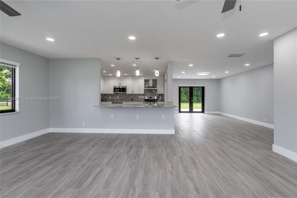 Empty room, Interior, Kitchen, Pendant Lights, Recessed Lighting, Stainless Steel Appliances, Wood Texture Flooring