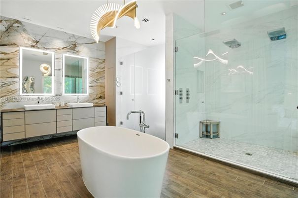 Bathroom, Dual Sink Vanities, Free Standing Baths, Glass Shower, Interior, Marble Walls, Recessed Lighting, Wood Texture Flooring