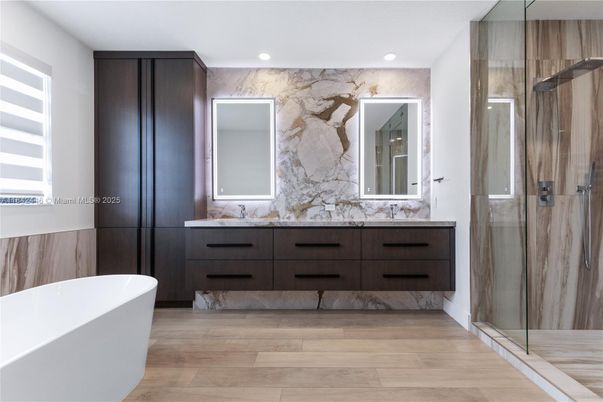 Bathroom, Dual Sink Vanities, Free Standing Baths, Glass Shower, Interior, Marble Walls, Recessed Lighting, Wood Texture Flooring