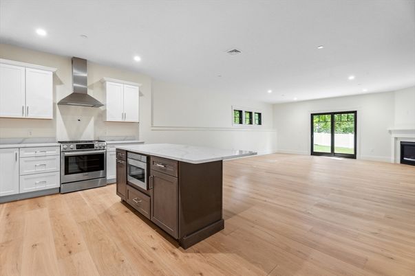 Empty room, Fireplace, Interior, Kitchen, Recessed Lighting, Stainless Steel Appliances, Wood Texture Flooring