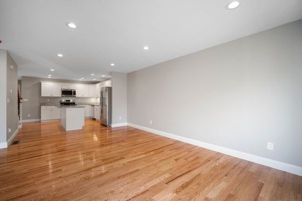 Empty room, Interior, Kitchen, Recessed Lighting, Stainless Steel Appliances, Wood Texture Flooring