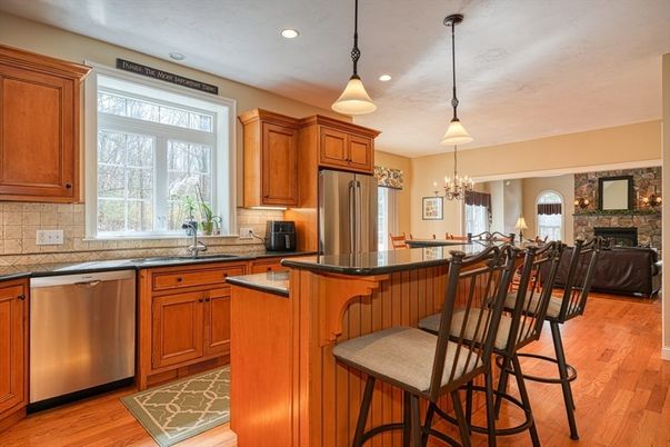 Chandelier, Fireplace, Interior, Kitchen, Pendant Lights, Recessed Lighting, Stainless Steel Appliances, Stone Walls, Wood Texture Flooring