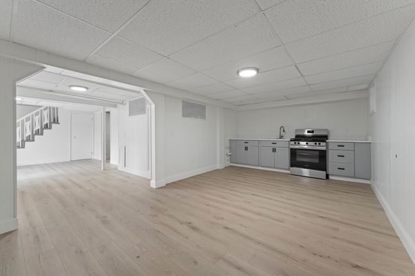 Empty room, Interior, Kitchen, Recessed Lighting, Stainless Steel Appliances, Wood Texture Flooring