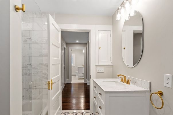 Bathroom, Dual Sink Vanities, Interior, Marble Walls, Recessed Lighting, Wood Texture Flooring