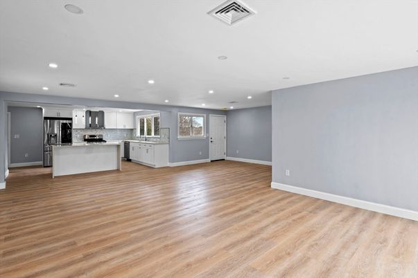 Empty room, Interior, Kitchen, Recessed Lighting, Stainless Steel Appliances, Wood Texture Flooring