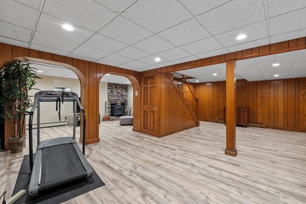 Fireplace, Fitness Equipment, Interior, Recessed Lighting, Stone Walls, Wood Texture Flooring, Wooden Walls
