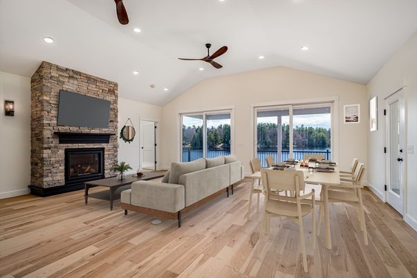 Dining room, Fireplace, Interior, Living room, Recessed Lighting, Stone Walls, Water, Wood Texture Flooring