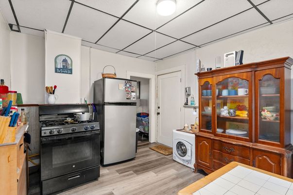 Interior, Kitchen, Tile Countertops, Washer, Wood Texture Flooring