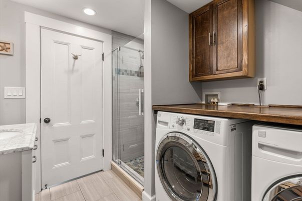 Bathroom, Glass Shower, Interior, Recessed Lighting, Washer, Wood Texture Flooring