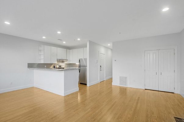 Empty room, Interior, Kitchen, Recessed Lighting, Stainless Steel Appliances, Wood Texture Flooring