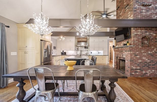 Chandelier, Dining room, Fireplace, Interior, Kitchen, Pendant Lights, Stainless Steel Appliances, Stone Walls, Wood Texture Flooring