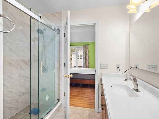 Bathroom, Dual Sink Vanities, Glass Shower, Interior, Marble Walls, Wood Texture Flooring
