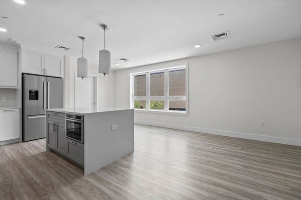 Empty room, Interior, Kitchen, Pendant Lights, Recessed Lighting, Stainless Steel Appliances, Wood Texture Flooring