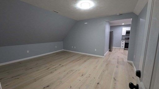 Empty room, Interior, Kitchen, Recessed Lighting, Stainless Steel Appliances, Wood Texture Flooring