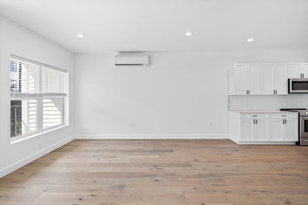 Empty room, Interior, Kitchen, Recessed Lighting, Stainless Steel Appliances, Wood Texture Flooring