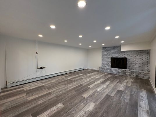 Empty room, Fireplace, Interior, Recessed Lighting, Stone Walls, Wood Texture Flooring