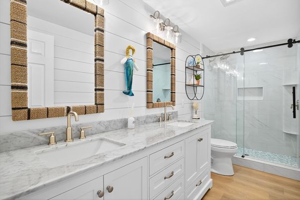 Bathroom, Dual Sink Vanities, Glass Shower, Interior, Marble Walls, Recessed Lighting, Wood Texture Flooring