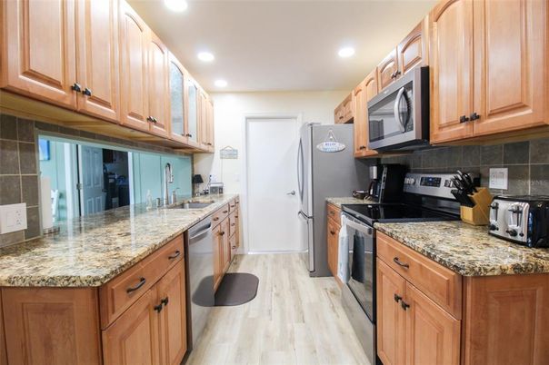 Interior, Kitchen, Wood Texture Flooring, Recessed Lighting, Stainless Steel Appliances, Tile Countertops