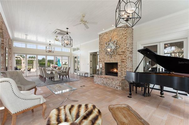 Chandelier, Dining room, Fireplace, Interior, Living room, Pendant Lights, Piano, Stone Walls, Wood Texture Flooring