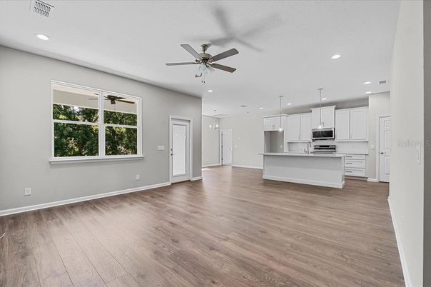 Empty room, Interior, Kitchen, Pendant Lights, Recessed Lighting, Stainless Steel Appliances, Wood Texture Flooring