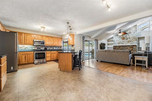 Fireplace, Interior, Kitchen, Living room, Pendant Lights, Stainless Steel Appliances, Stone Walls, Wood Texture Flooring