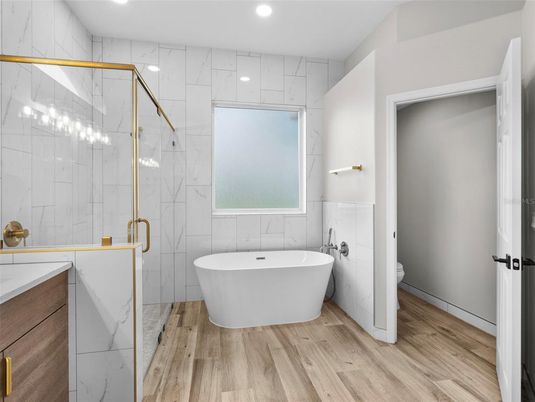 Bathroom, Free Standing Baths, Glass Shower, Interior, Marble Walls, Recessed Lighting, Wood Texture Flooring