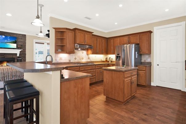 Fireplace, Interior, Kitchen, Pendant Lights, Recessed Lighting, Stainless Steel Appliances, Stone Walls, Wood Texture Flooring