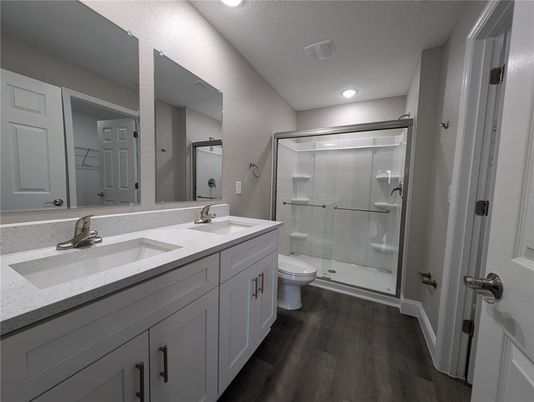 Bathroom, Dual Sink Vanities, Glass Shower, Interior, Recessed Lighting, Wood Texture Flooring