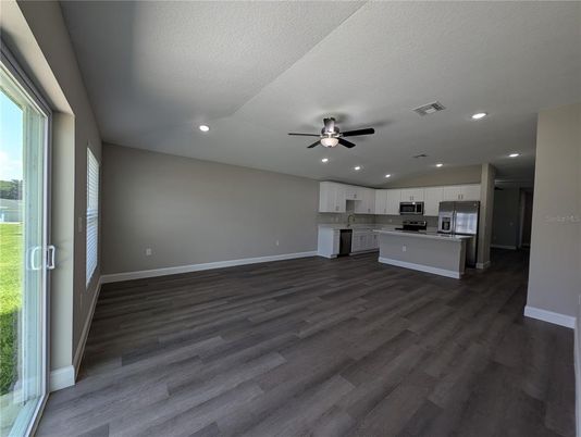 Empty room, Interior, Kitchen, Recessed Lighting, Stainless Steel Appliances, Wood Texture Flooring