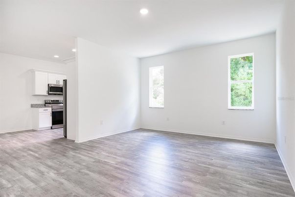 Empty room, Interior, Kitchen, Recessed Lighting, Stainless Steel Appliances, Wood Texture Flooring
