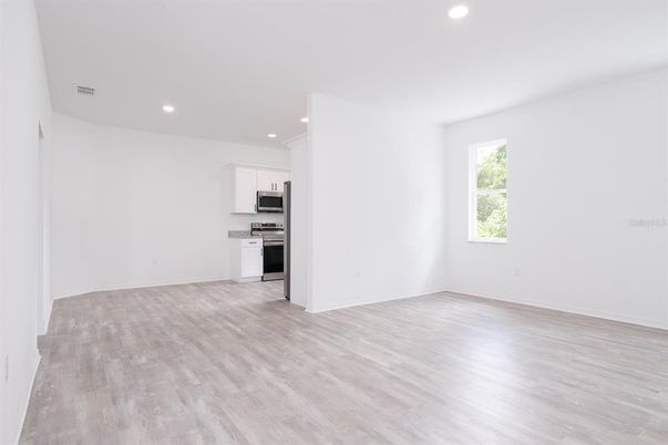 Empty room, Interior, Kitchen, Recessed Lighting, Stainless Steel Appliances, Wood Texture Flooring