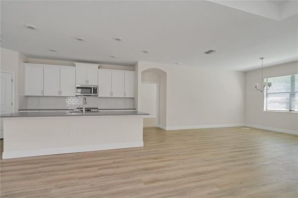 Empty room, Interior, Kitchen, Pendant Lights, Recessed Lighting, Stainless Steel Appliances, Wood Texture Flooring