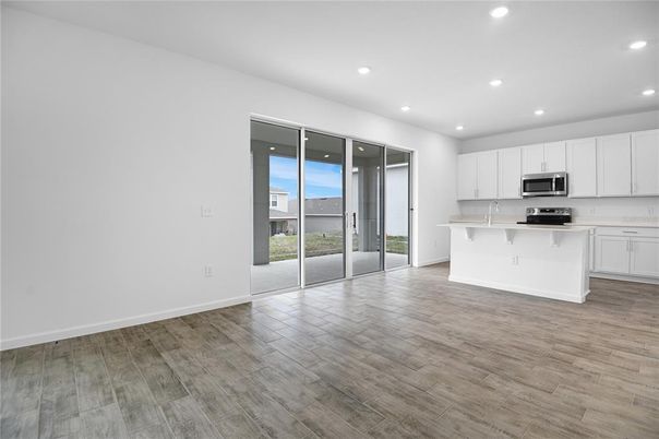 Empty room, Interior, Kitchen, Recessed Lighting, Stainless Steel Appliances, Wood Texture Flooring