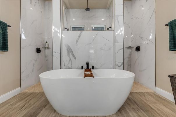 Bathroom, Free Standing Baths, Glass Shower, Interior, Marble Walls, Recessed Lighting, Wood Texture Flooring