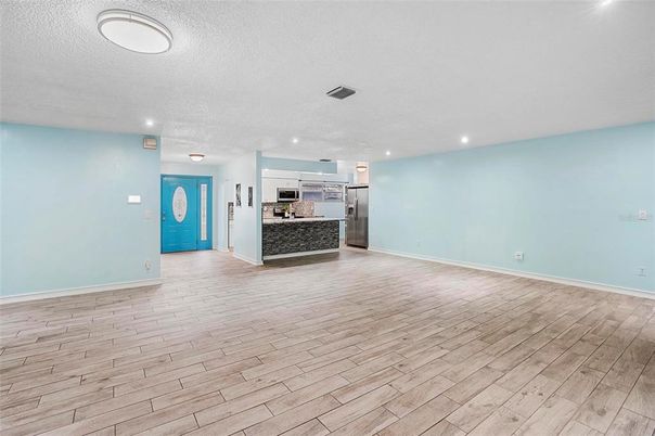 Empty room, Interior, Kitchen, Recessed Lighting, Stainless Steel Appliances, Wood Texture Flooring
