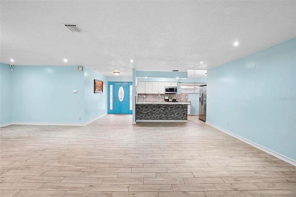 Empty room, Interior, Kitchen, Recessed Lighting, Stainless Steel Appliances, Wood Texture Flooring