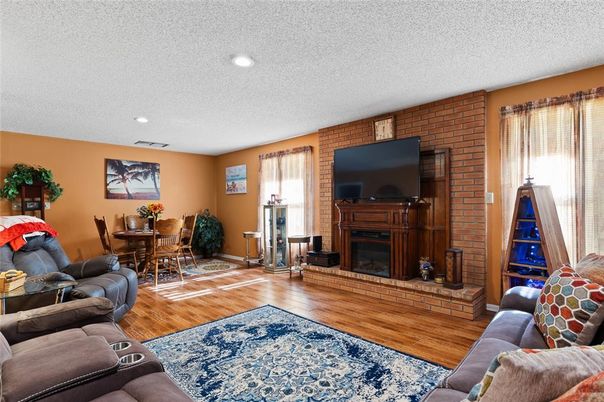 Dining room, Fireplace, Interior, Living room, Recessed Lighting, Stone Walls, Wood Texture Flooring