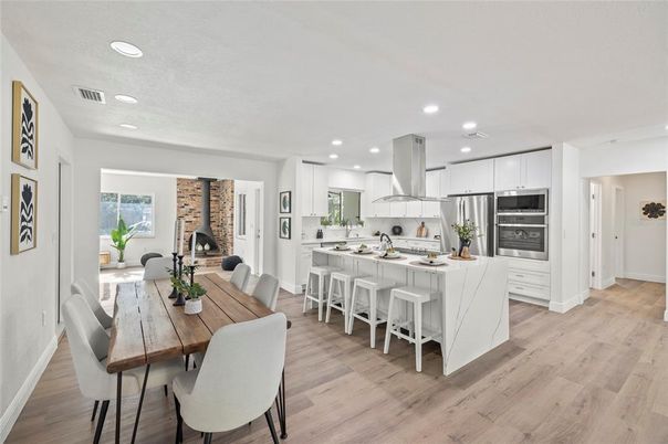 Dining room, Fireplace, Interior, Kitchen, Recessed Lighting, Stainless Steel Appliances, Stone Walls, Wood Texture Flooring