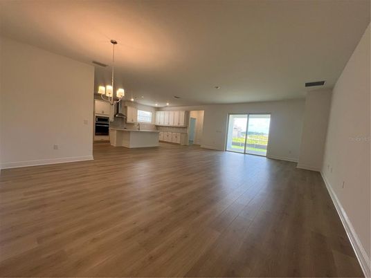 Empty room, Interior, Kitchen, Pendant Lights, Recessed Lighting, Stainless Steel Appliances, Wood Texture Flooring