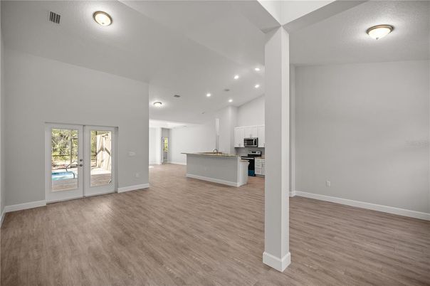 Empty room, Interior, Kitchen, Recessed Lighting, Stainless Steel Appliances, Wood Texture Flooring