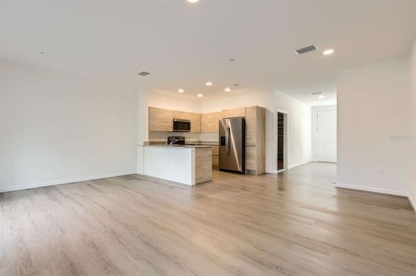 Empty room, Interior, Kitchen, Recessed Lighting, Stainless Steel Appliances, Wood Texture Flooring