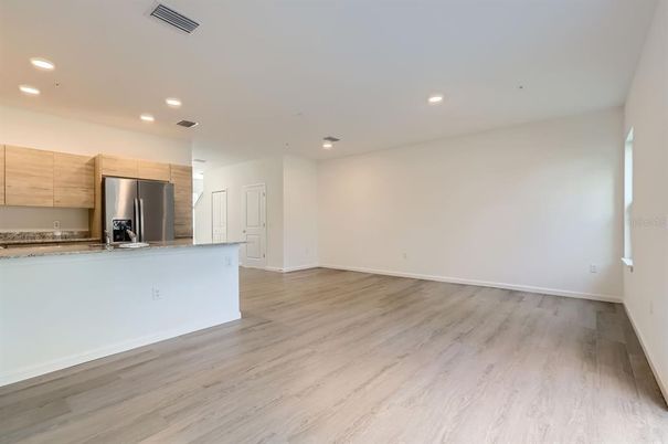 Empty room, Interior, Kitchen, Recessed Lighting, Stainless Steel Appliances, Wood Texture Flooring