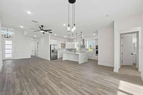 Empty room, Interior, Kitchen, Pendant Lights, Recessed Lighting, Stainless Steel Appliances, Wood Texture Flooring